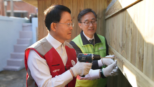 하석주 롯데건설 대표(왼쪽)와 유성훈 금천구청장이 지난달 28일 서울 금천구 독산동에 위치한 장애인지원시설 '기쁨이 싹트는 나무'에서 봉사활동을 하고 있다.  롯데건설 제공